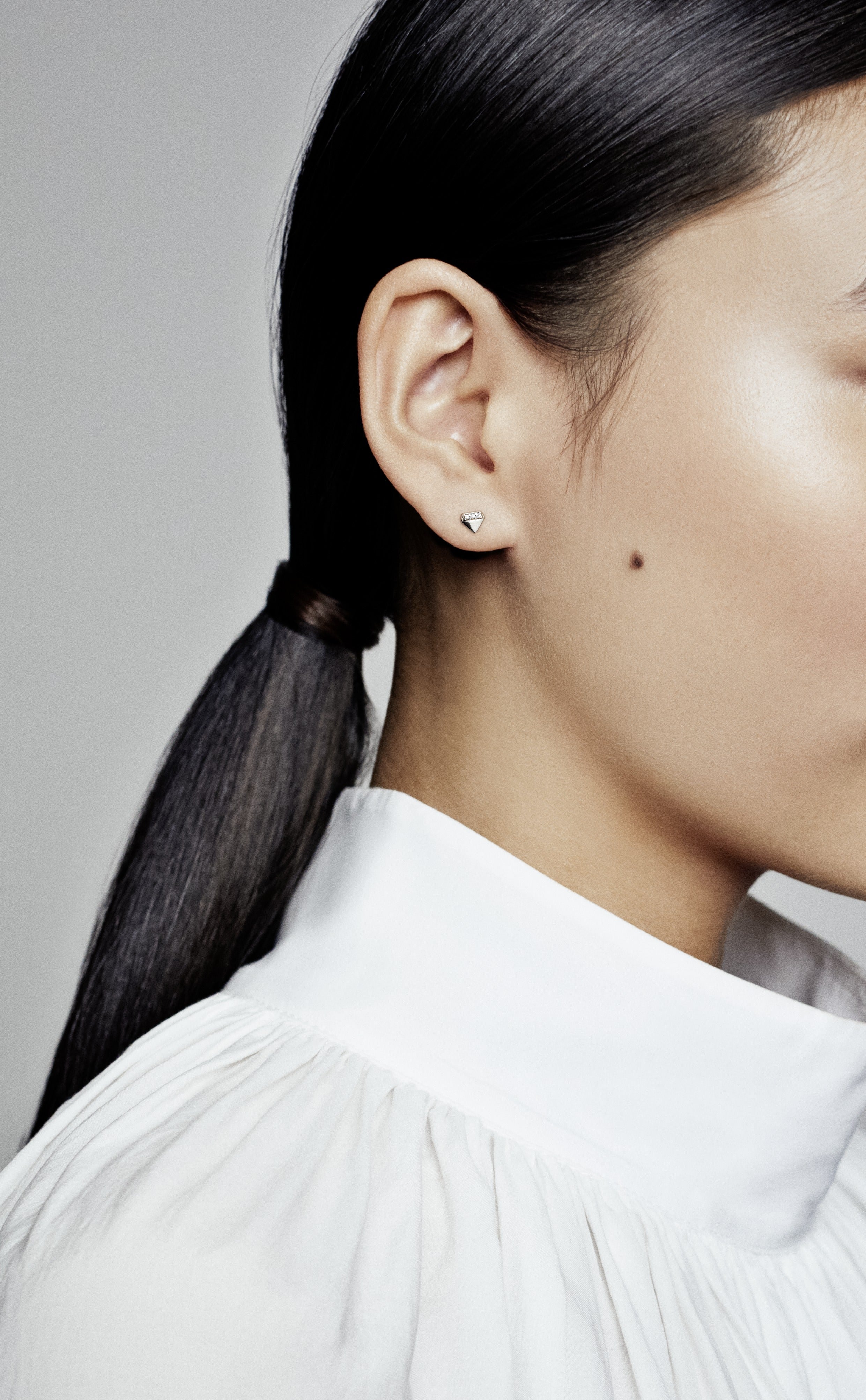 Diamond-shaped sterling silver stud earring with clear cubic zirconia