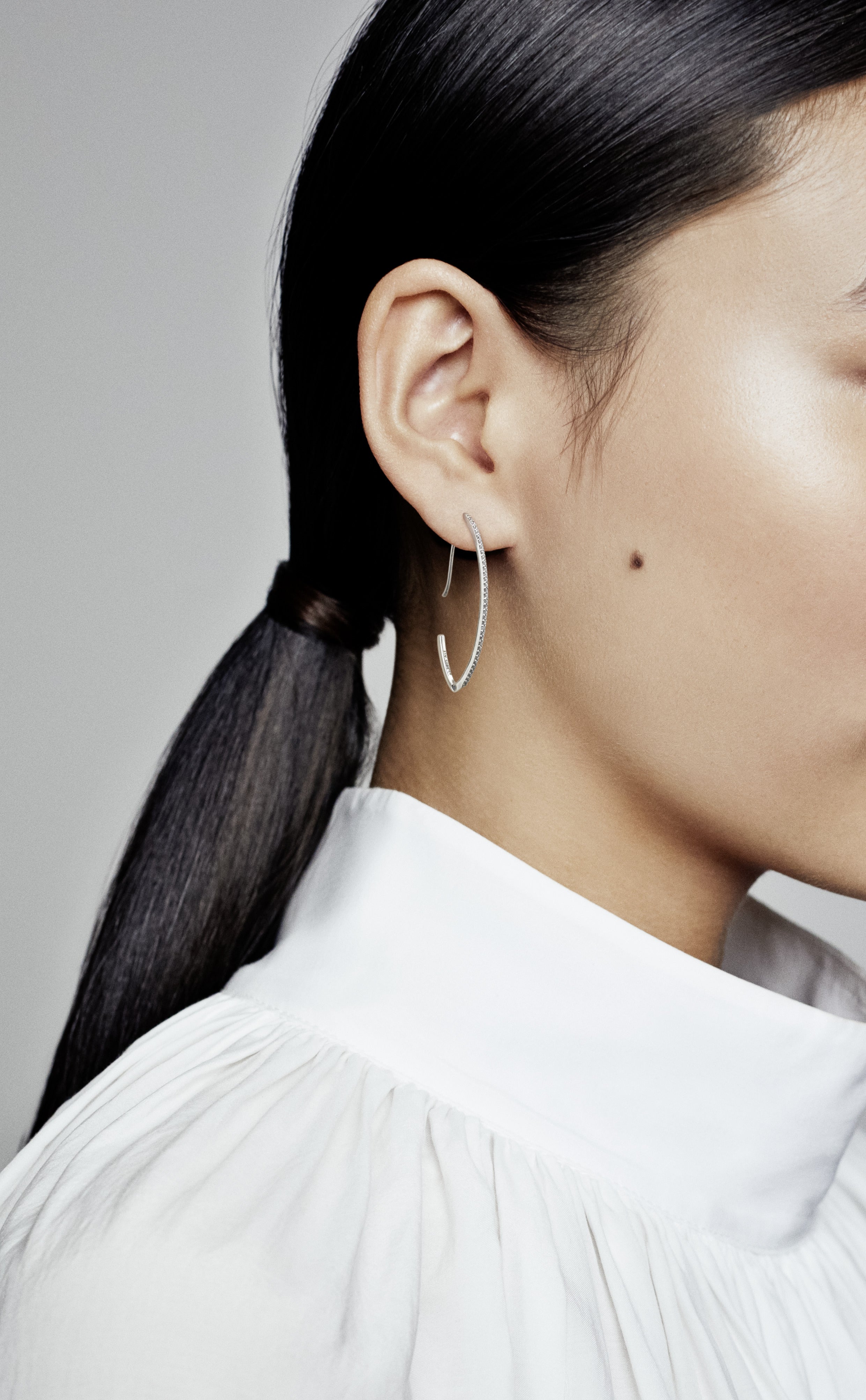 Silver oval hoop earrings with clear cubic zirconia